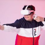 Homem usa um headset de realidade virtual e controles em um ambiente interno.