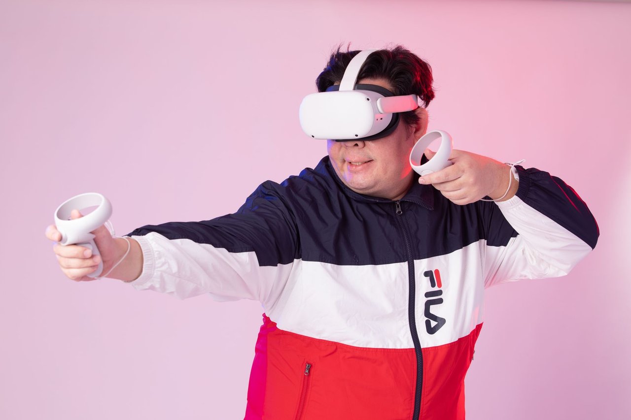 Homem usa um headset de realidade virtual e controles em um ambiente interno.