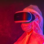 Pessoa usando equipamento de proteção e headset de realidade virtual em um ambiente iluminado por luzes neon